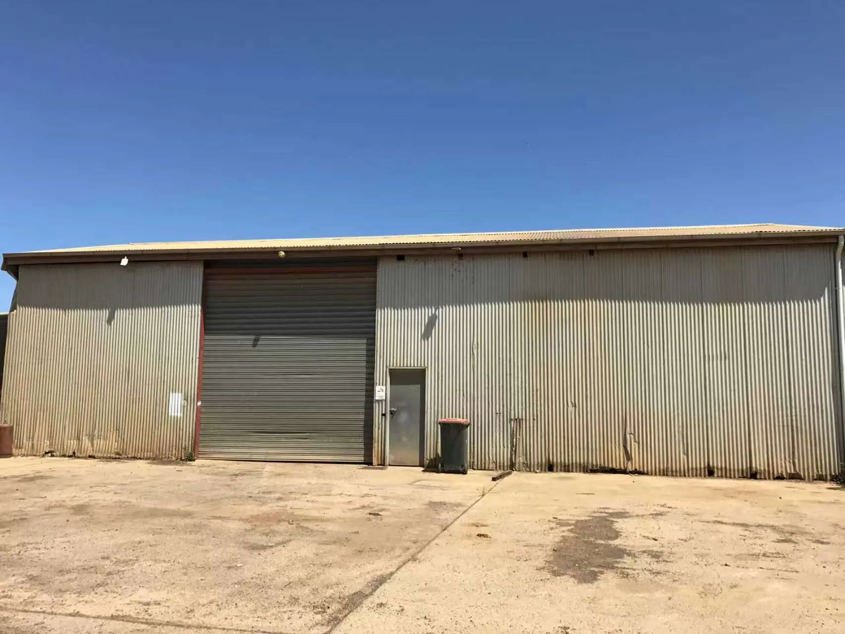 Exterior of an early WinHarvest warehouse under a clear blue sky